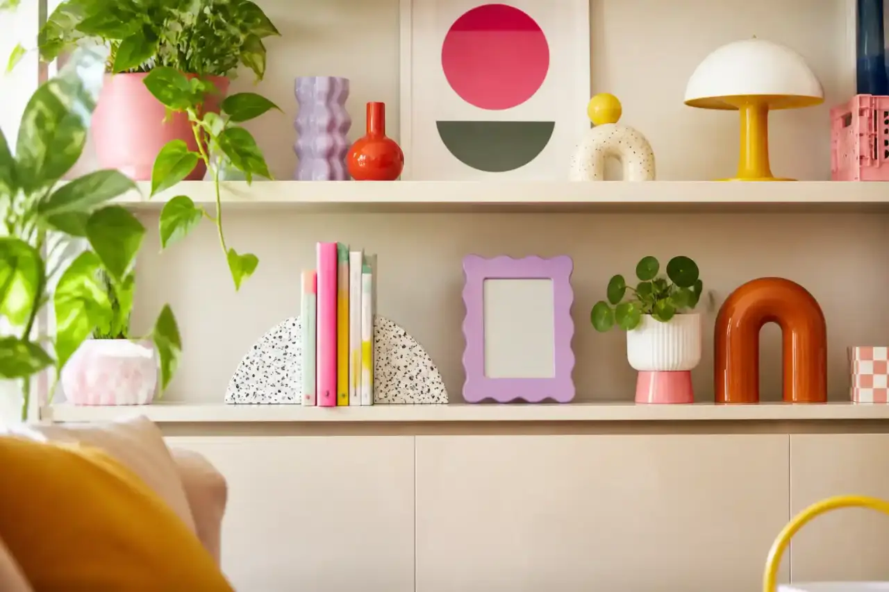 Étagère pop colorée avec vases, livres, luminaire design et objets Memphis
